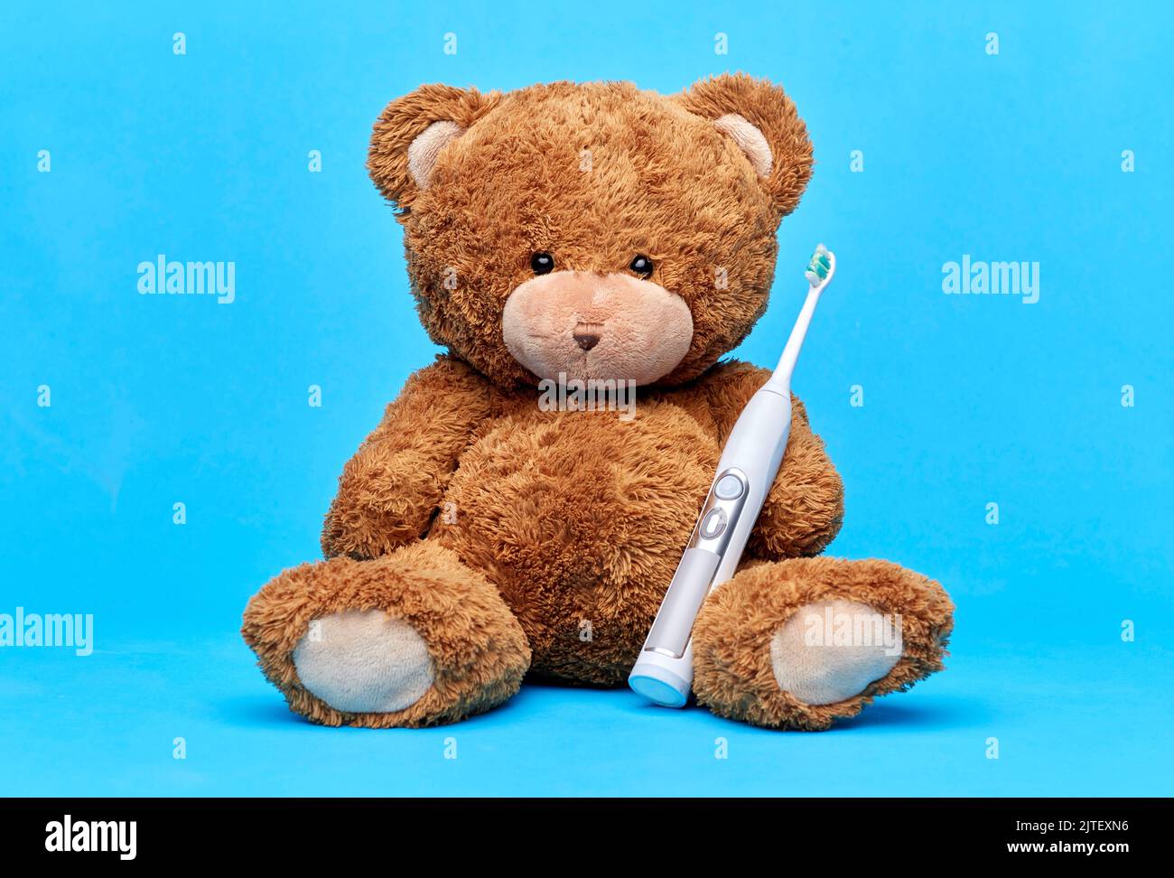 teddy bear toy with electric toothbrush Stock Photo Alamy