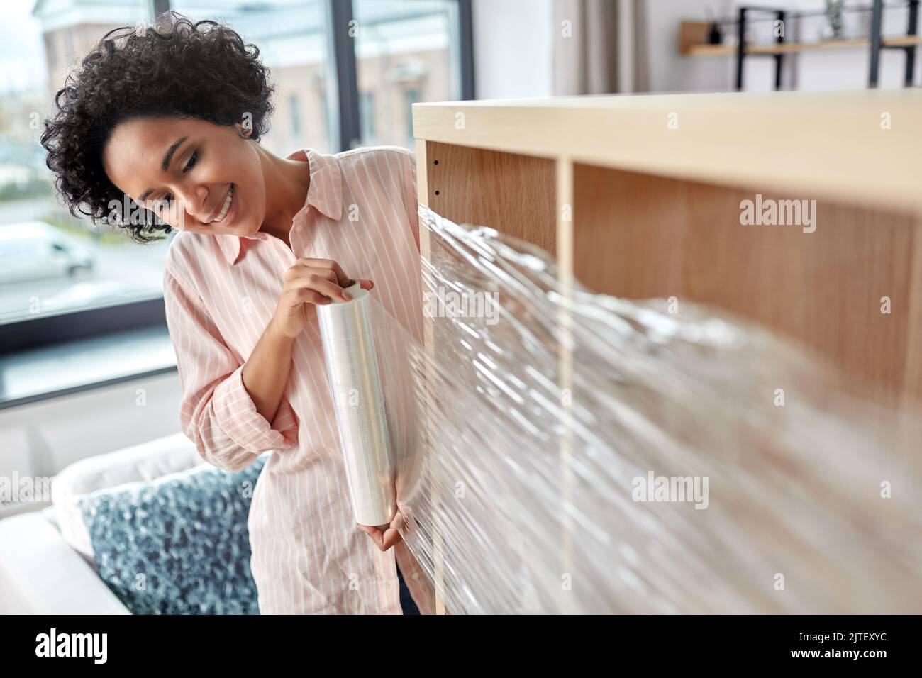 happy woman packing shelf and moving to new home Stock Photo Alamy