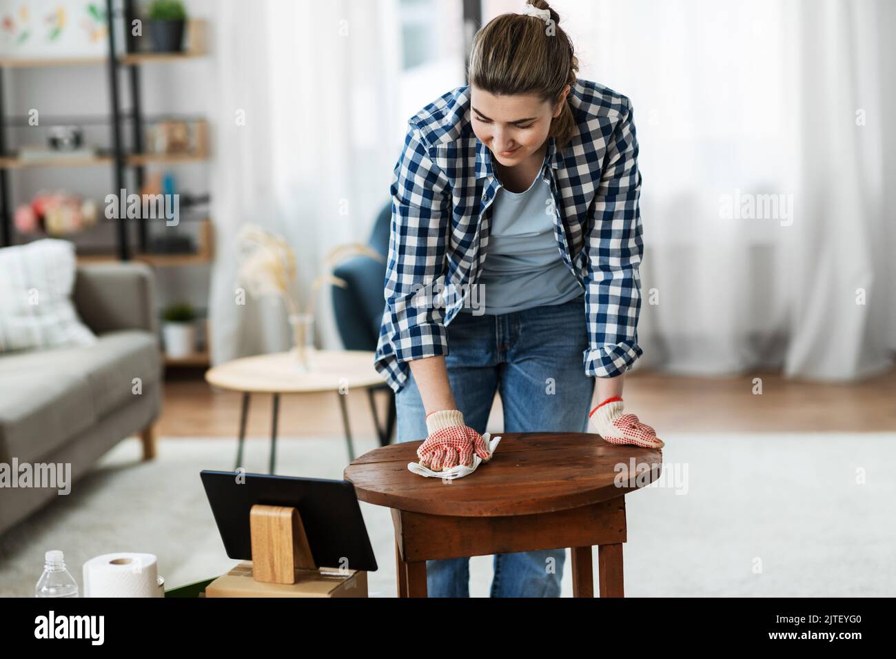 woman with tablet pc cleaning table with tissue Stock Photo - Alamy