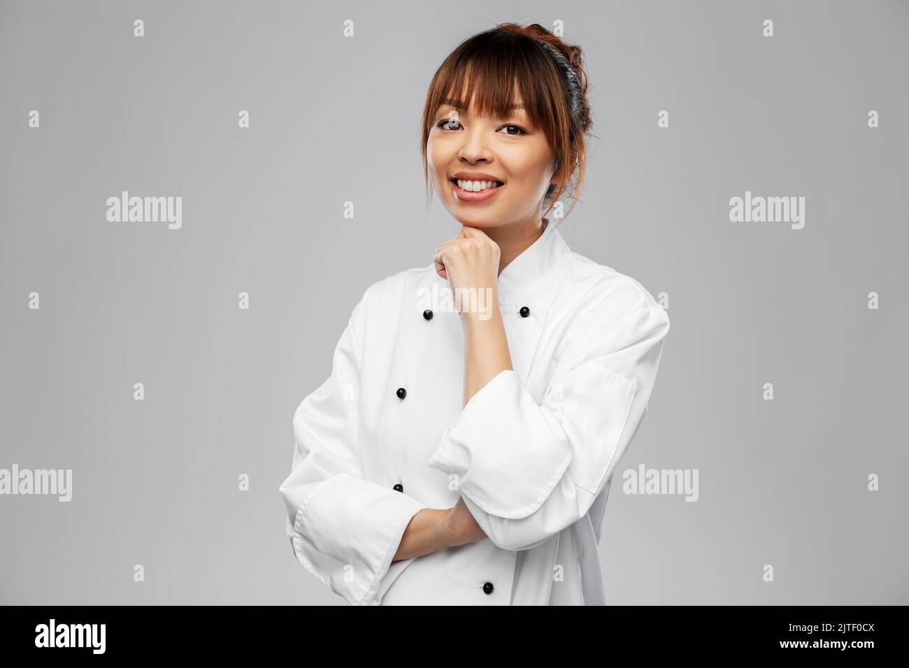 smiling female chef in white jacket Stock Photo