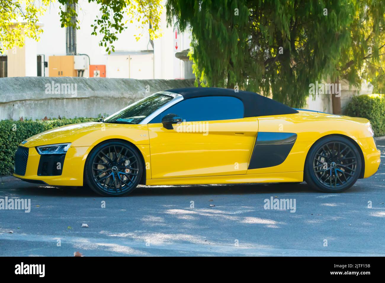 Audi R8 luxury and performance motor car, side on and yellow, parked in a road Stock Photo
