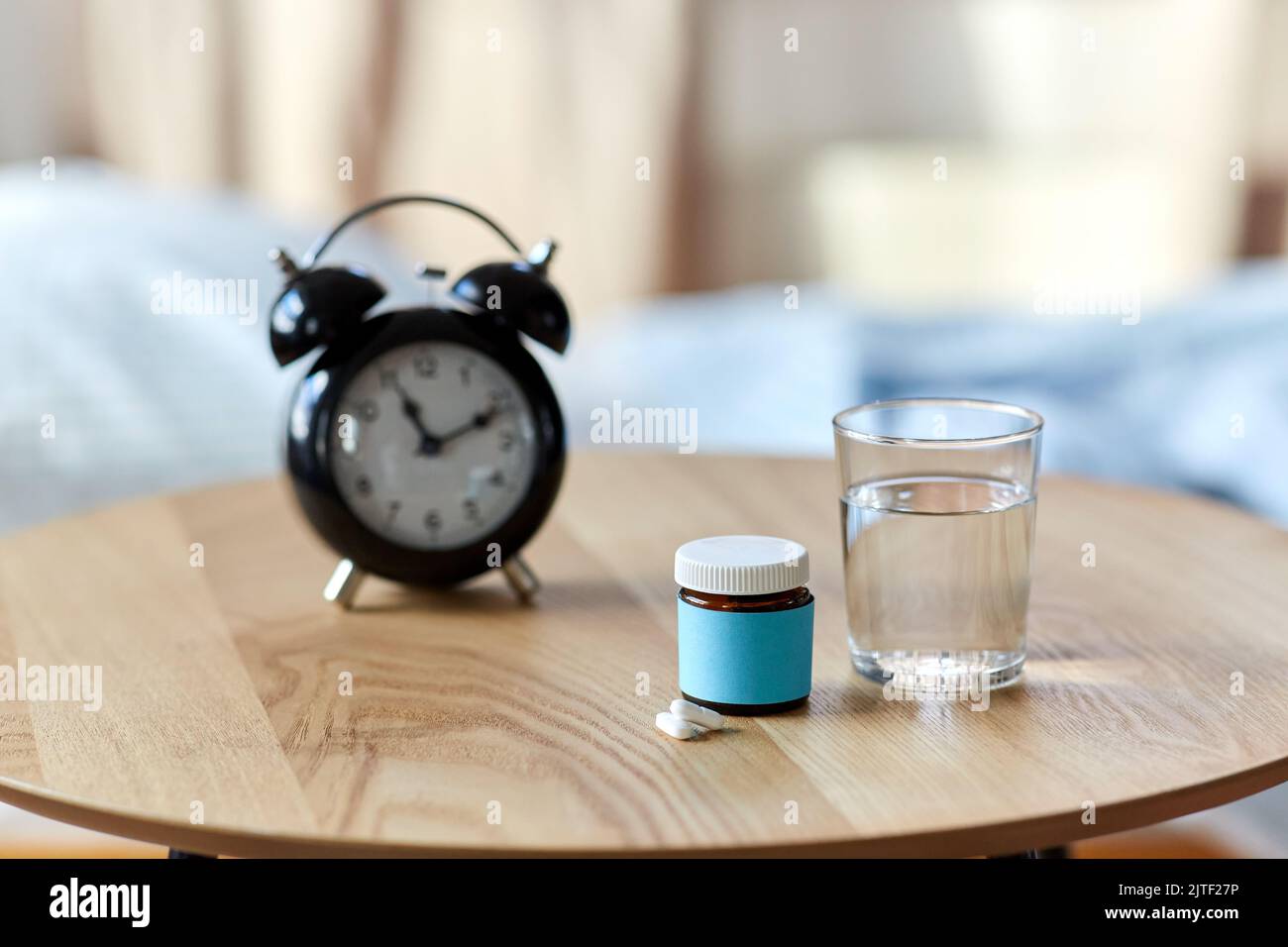 alarm clock, sleeping pills and glass of water Stock Photo