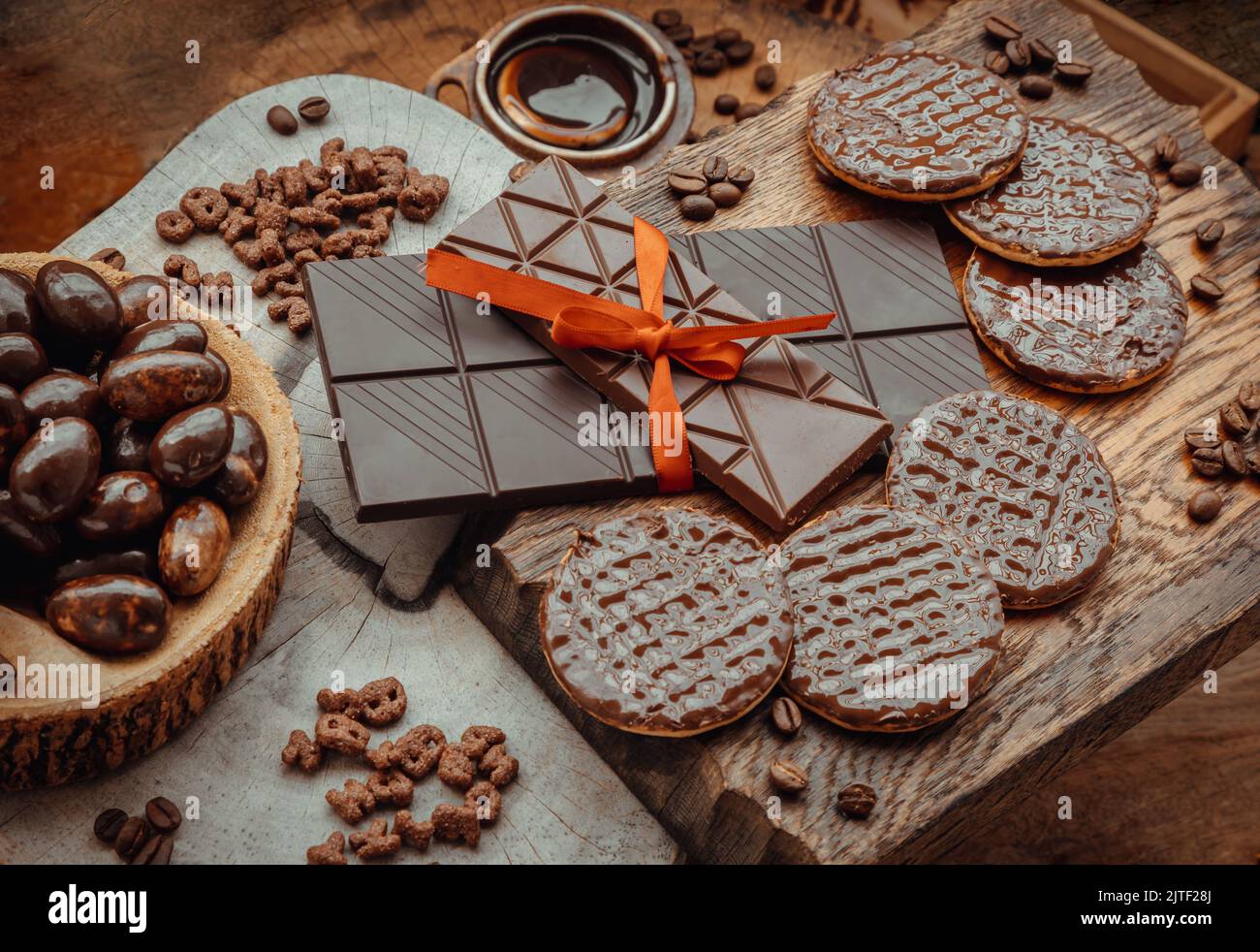 Composition of different Dark chocolate bars and pieces, Melted chocolate and Coffee beans on Old wooden background. Selective Focus. Stock Photo