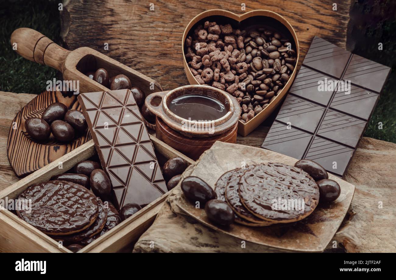 Composition of different Dark chocolate bars and pieces, Melted chocolate and Coffee beans on Old wooden background. Selective Focus. Stock Photo