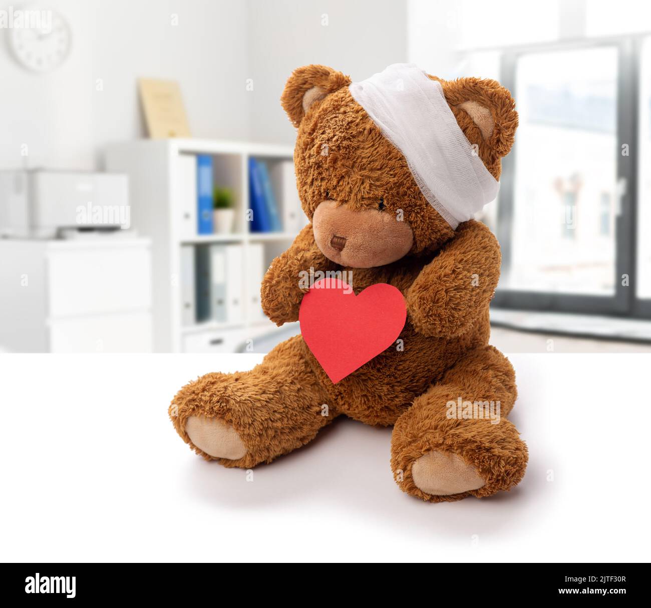 teddy bear toy with bandaged head and red heart Stock Photo - Alamy