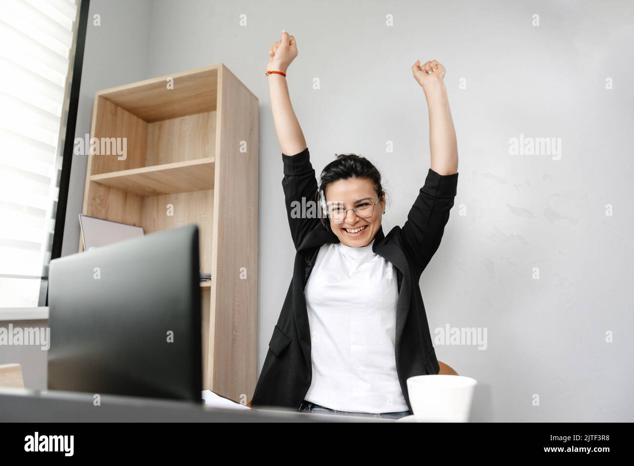 Smiling female freelancer using laptop, researching online, working from home, happy casual millennial guy typing on laptop PC, browsing the internet Stock Photo