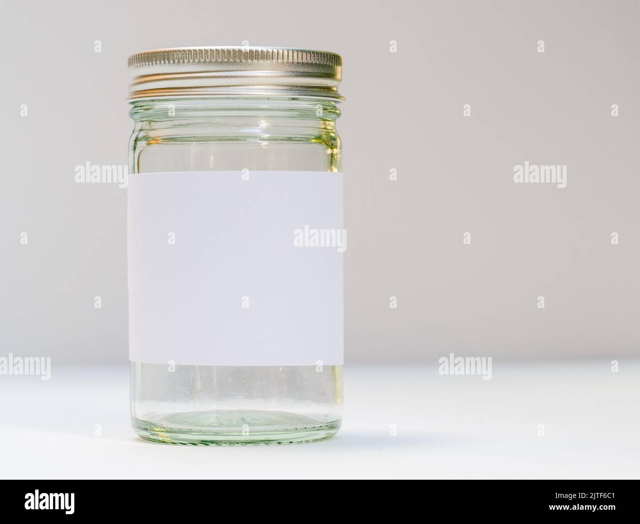 silver screw top glass jar with clean white label Stock Photo