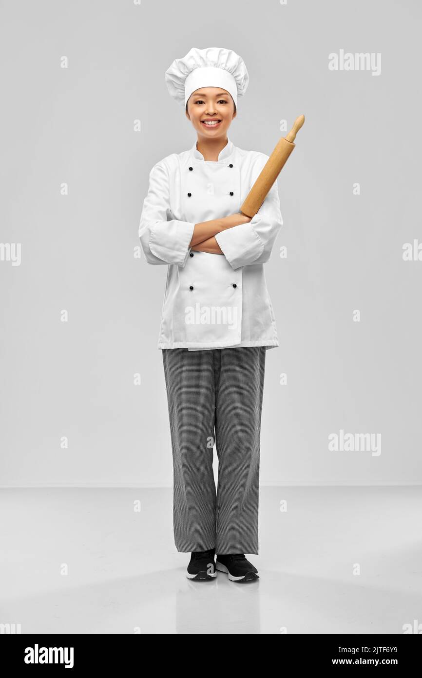 smiling female chef or baker with rolling pin Stock Photo
