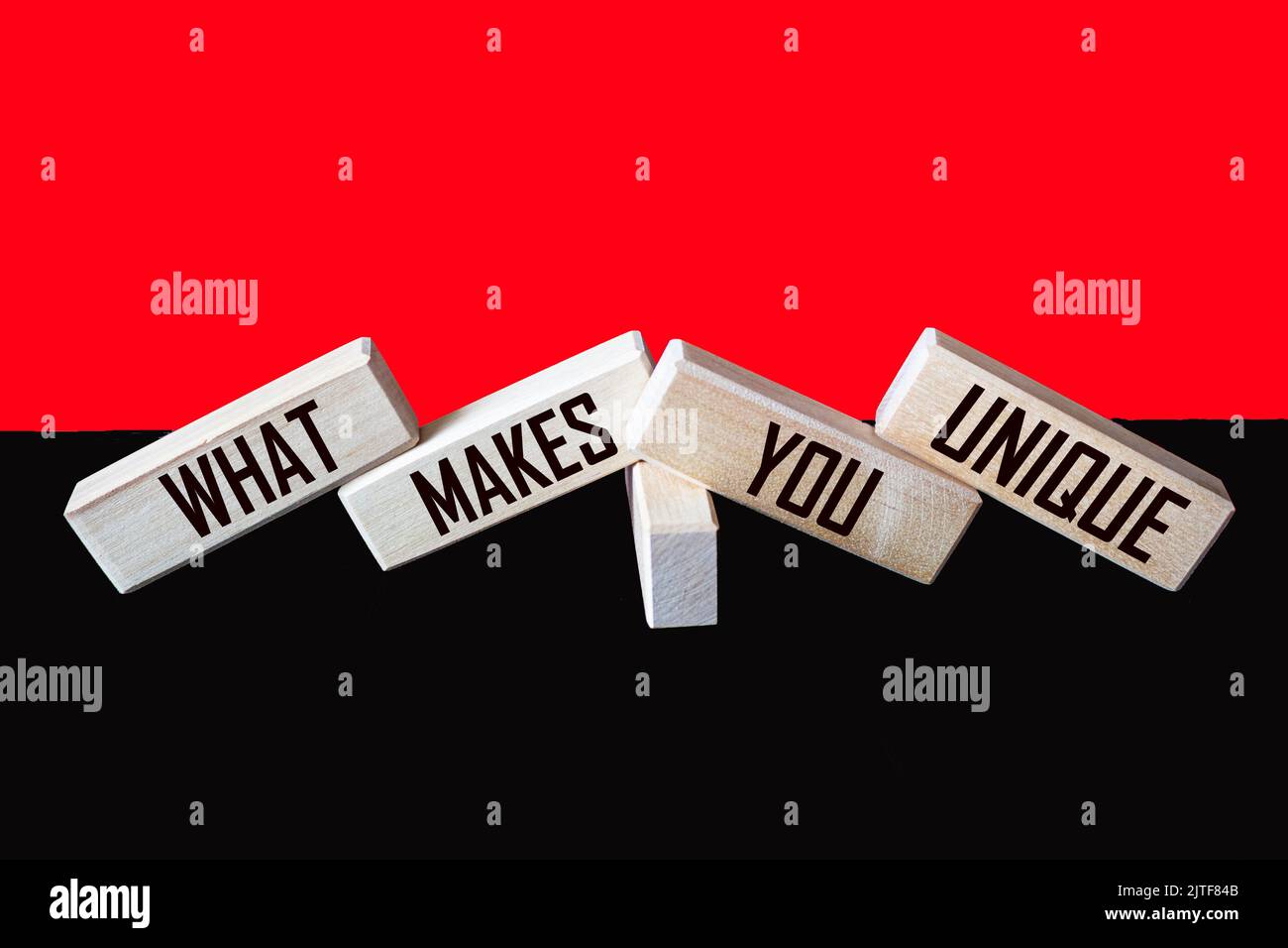 What Makes You Unique written on wooden blocks and red and black background Stock Photo