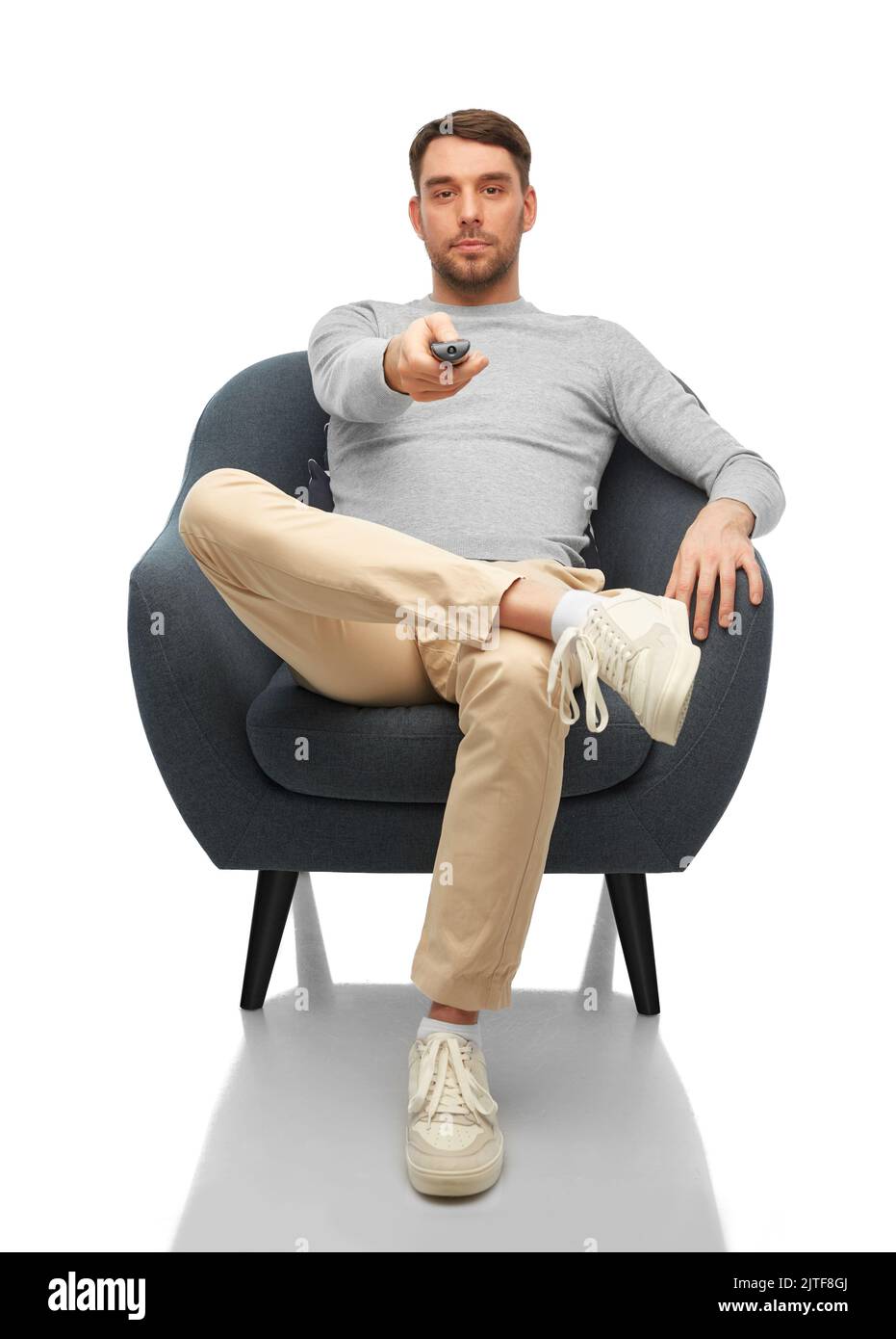 man with tv remote control sitting in chair Stock Photo