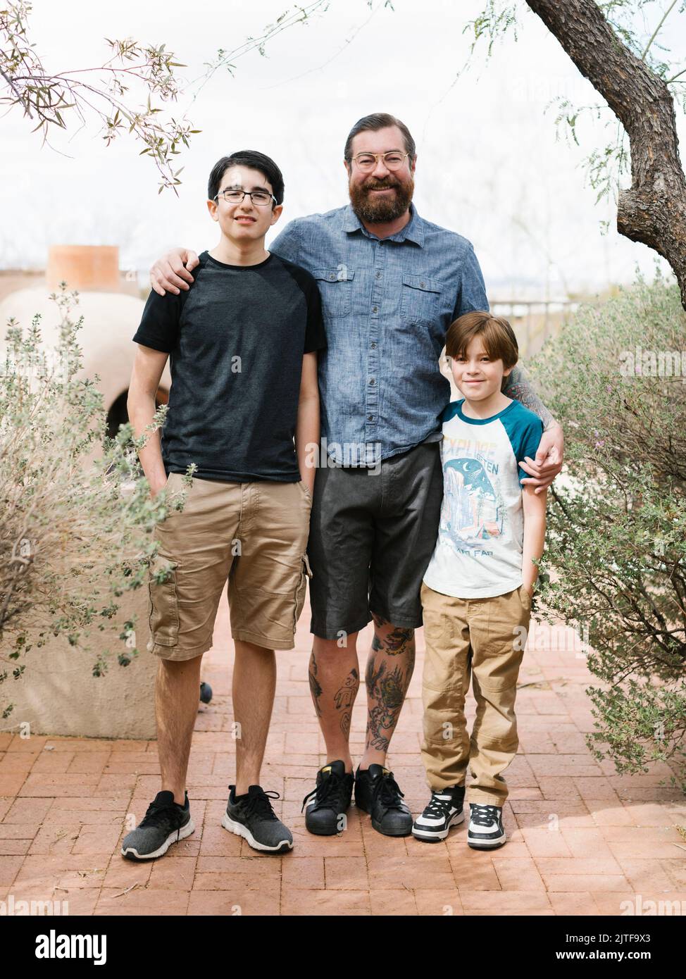 Portrait of father with two sons (8-9, 14-15) Stock Photo