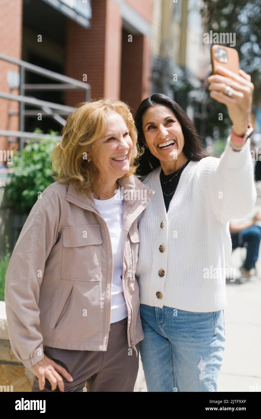 Smiling female friends taking selfie Stock Photo