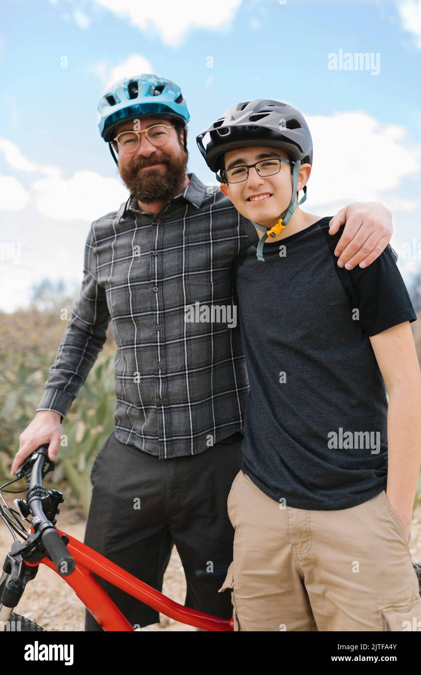 Portrait of father and son (14-15) in bike helmets Stock Photo