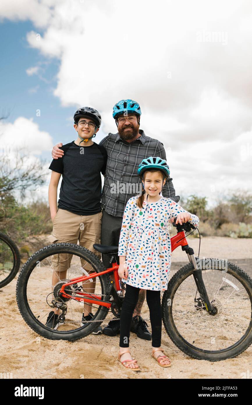 Portrait of father with children (8-9, 14-15) with bikes Stock Photo
