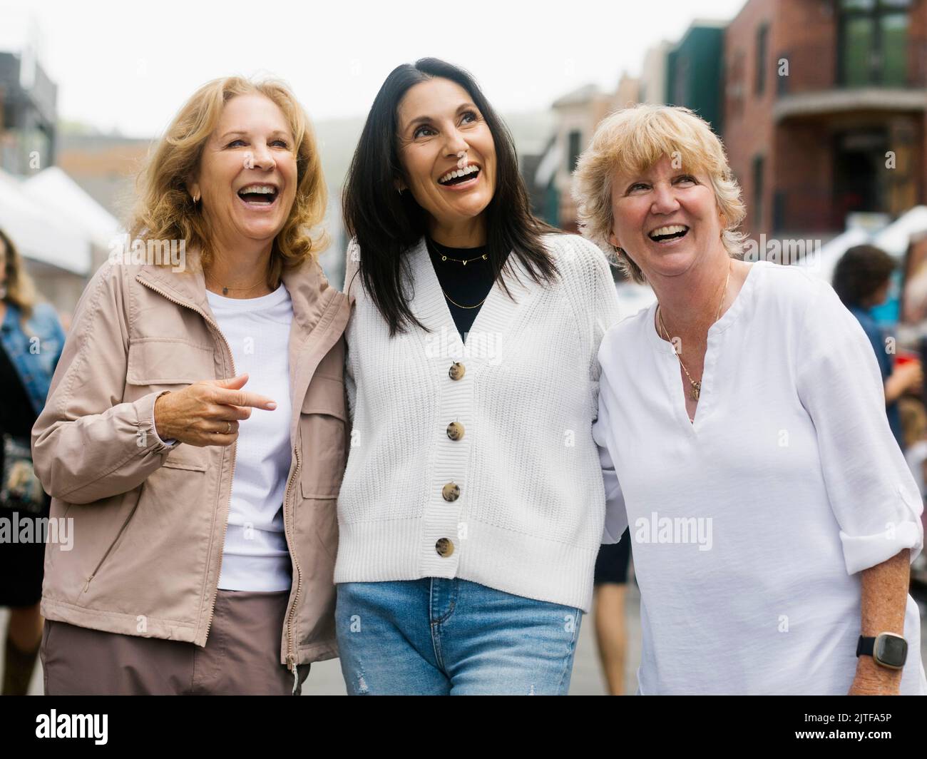 Three women walking through street market Stock Photo - Alamy