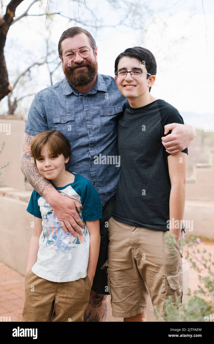 Portrait of father with two sons (8-9, 14-15) Stock Photo
