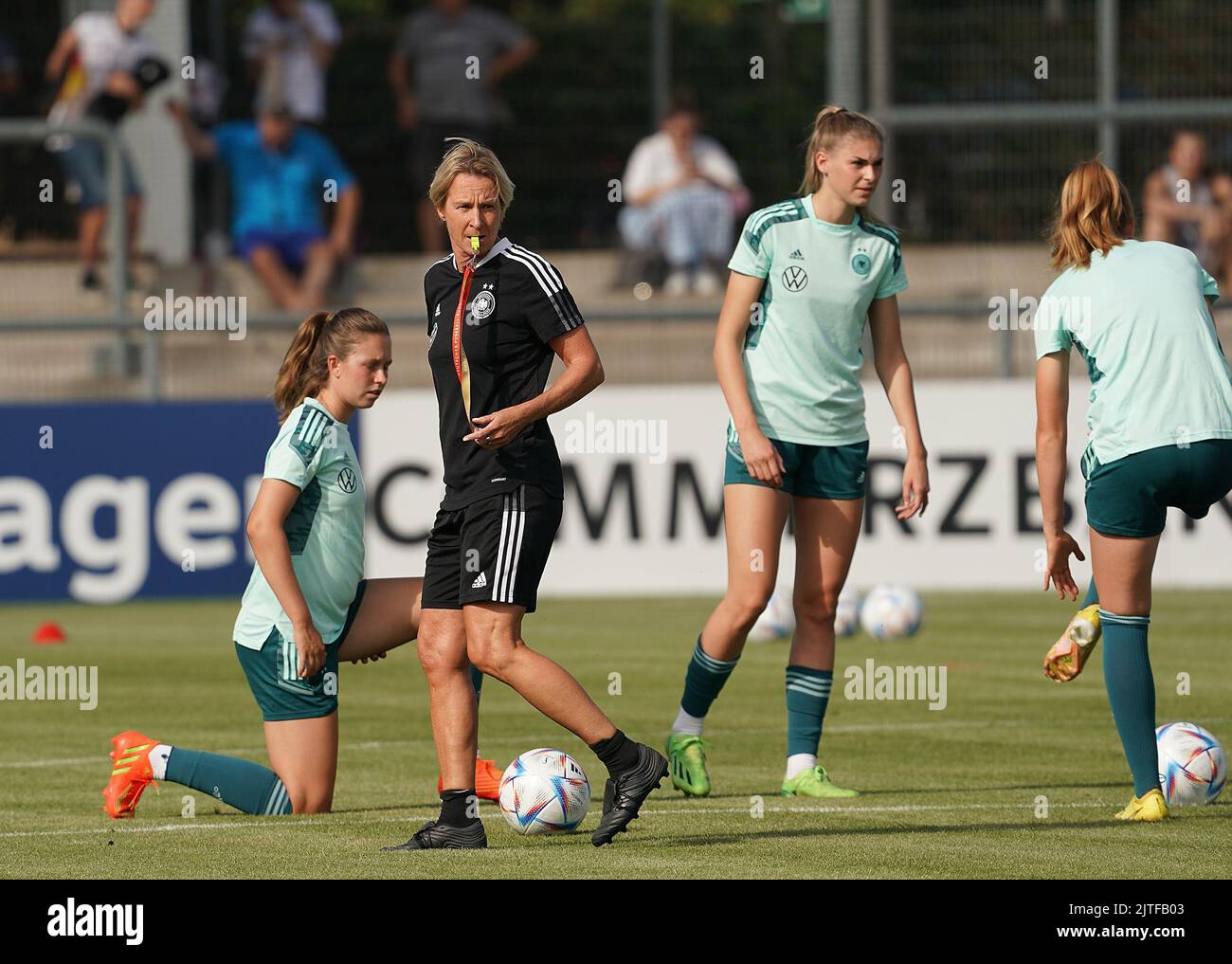 30 August 2022, Hessen, Frankfurt/Main: Soccer: Women, before the World Cup qualifier in Turkey, Public training at the Stadium am Bretanobad. National coach Martina Voss-Tecklenburg (2.vr) from Germany gives instructions to her team. Photo: Hasan Bratic/dpa Stock Photo