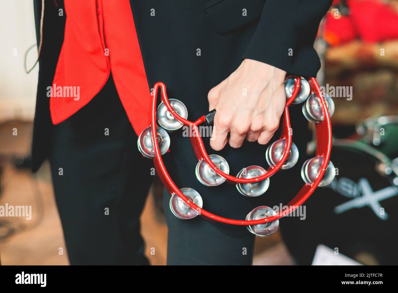 Female musician playing tambourine and singing into microphone, with