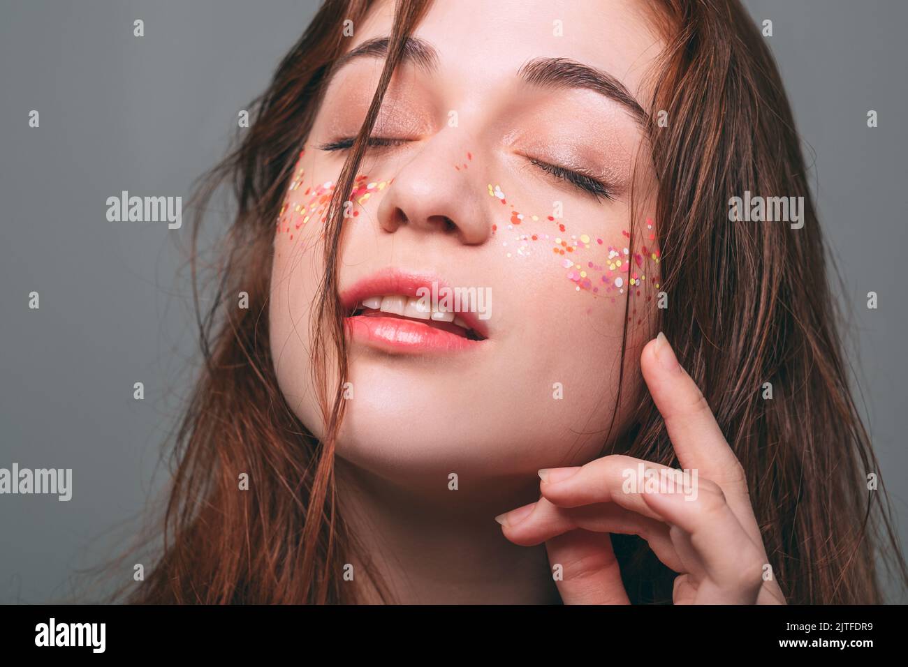 young beautiful female glitter makeup eyes closed Stock Photo