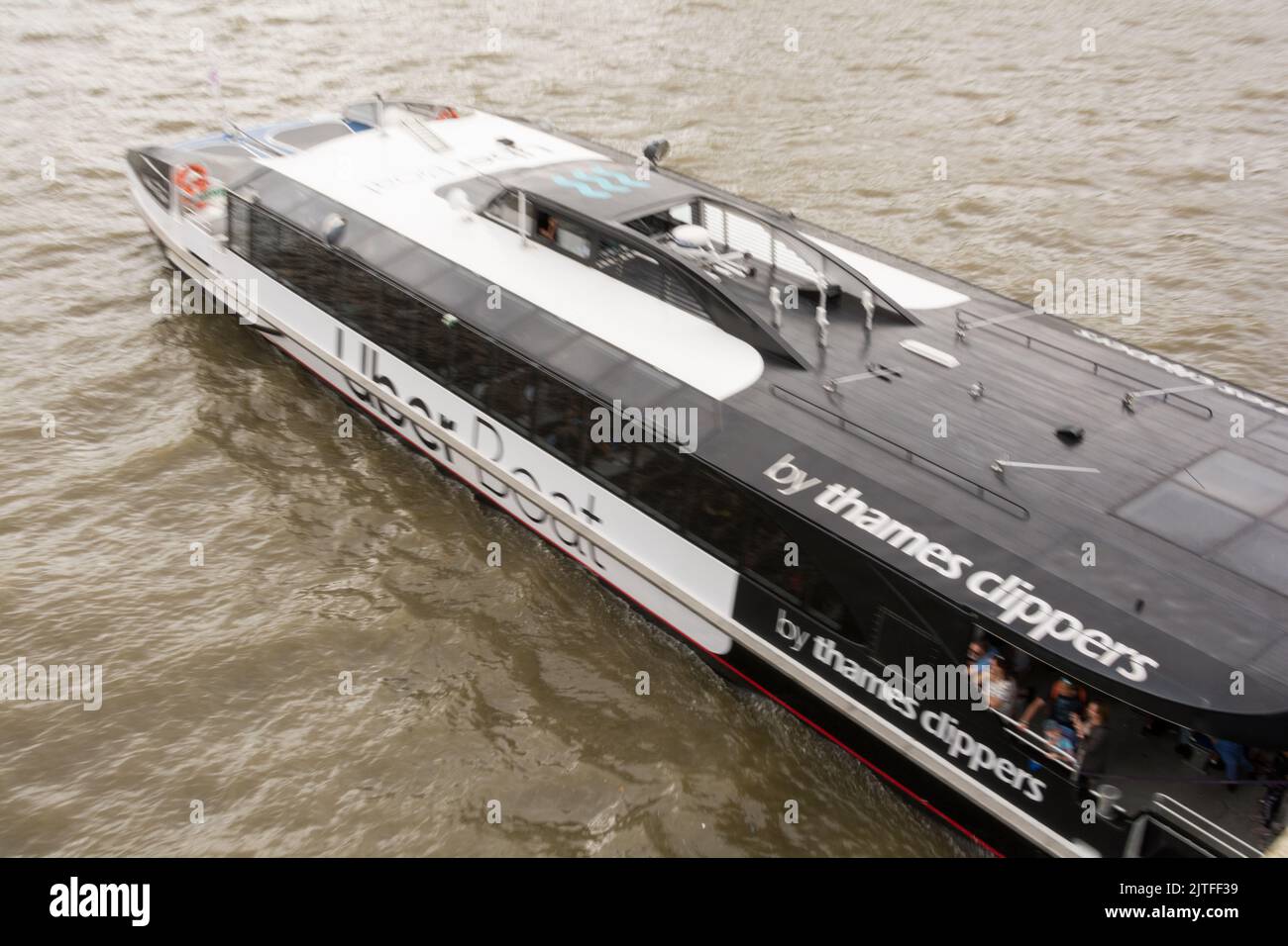 Side View and close up of a Thames Clipper Uber Boat on the River Thames, London, England, UK Stock Photo