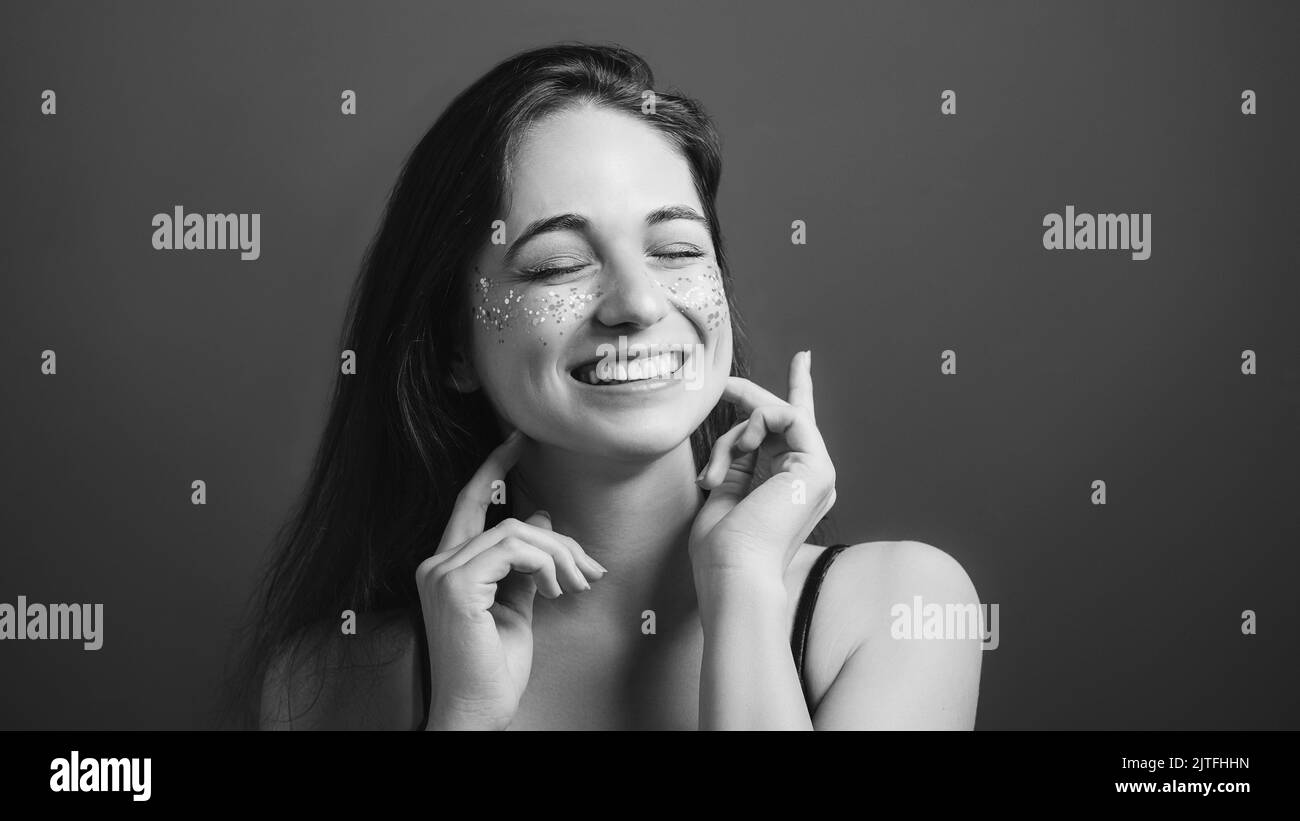 young woman portrait fake smile eyes closed Stock Photo