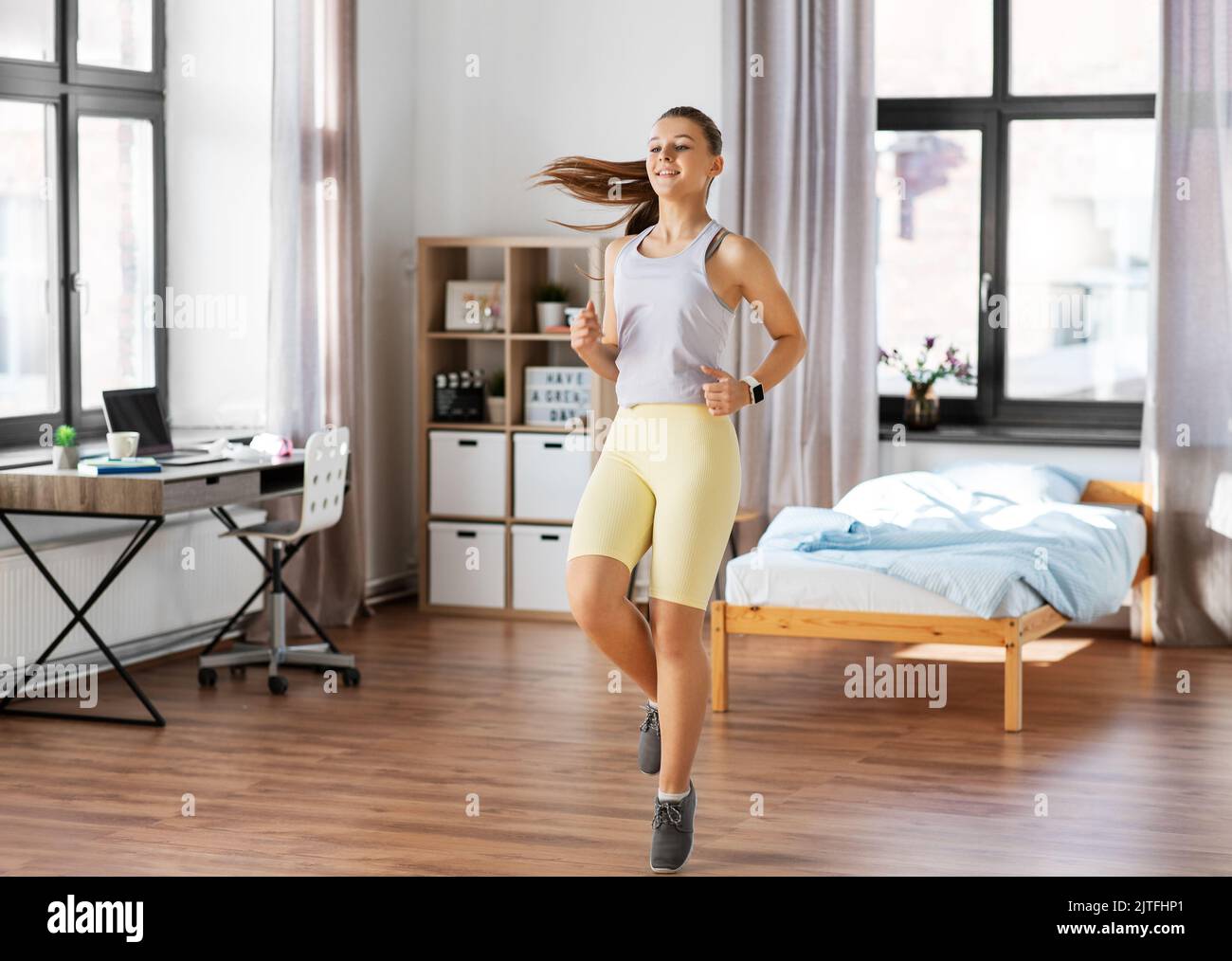 smiling teenage girl running on spot at home Stock Photo Alamy