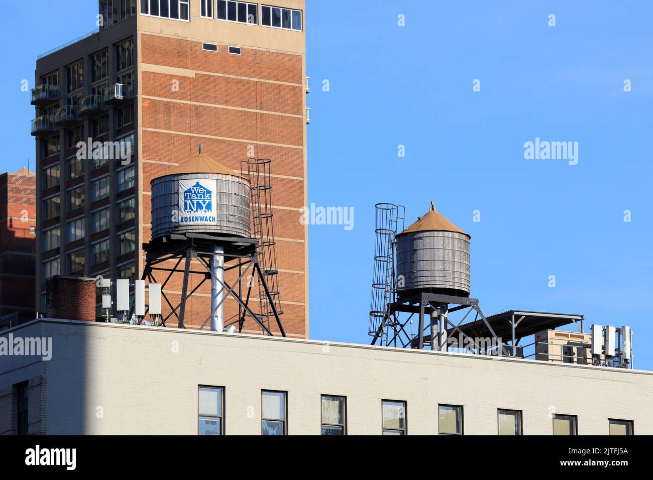 Rosenwach wood water tanks on a New York City rooftop. Water tanks are used to store water to maintain water pressure in a building. Stock Photo