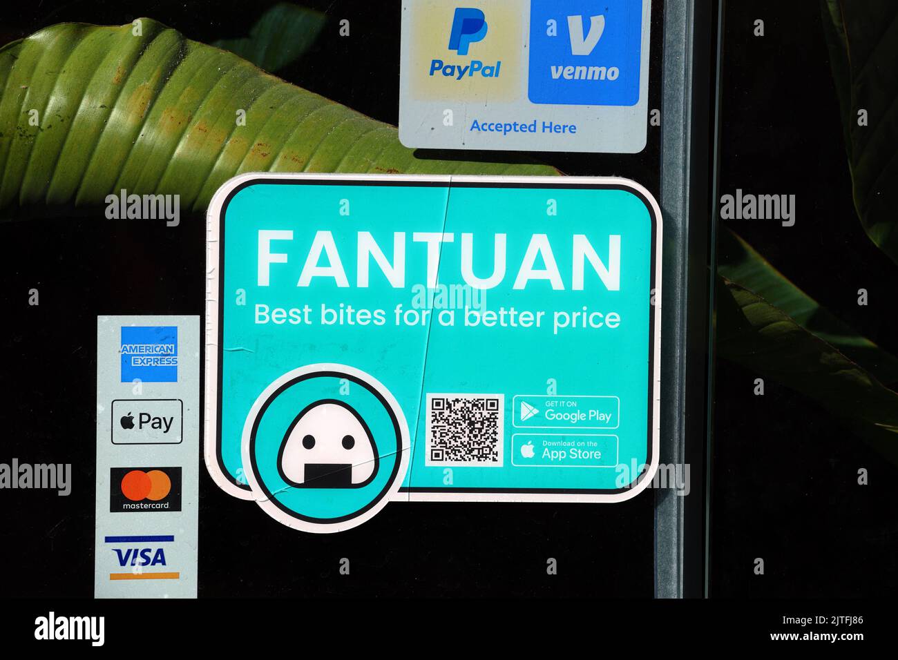 A Fantuan food delivery sticker on the door to a restaurant. A 飯糰外賣  Asian food delivery services app. Stock Photo
