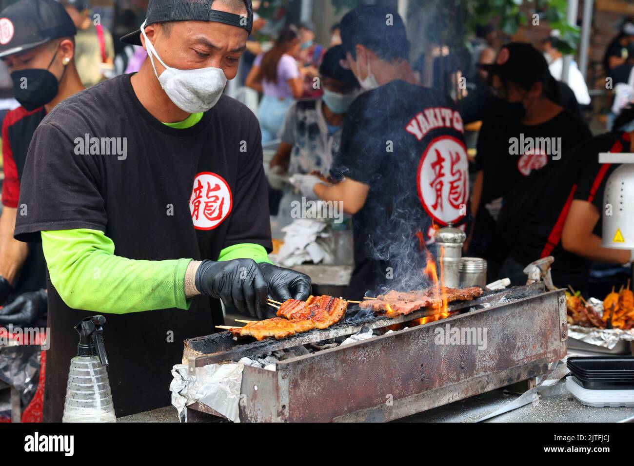 A Yakitori Tatsu chef prepares kushiyaki and yakitori on a konro with binchotan charcoal at a street fair, New York. skewers on a charcoal grill. Stock Photo