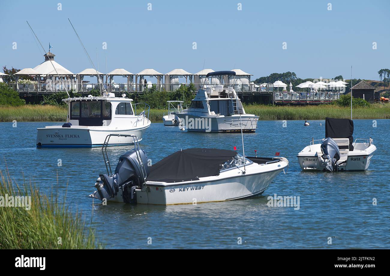 Boats at their mooring with Wequassett Inn cabanas in the background on Round Cove, Harwich, Massachusetts, on Cape Cod, USA Stock Photo