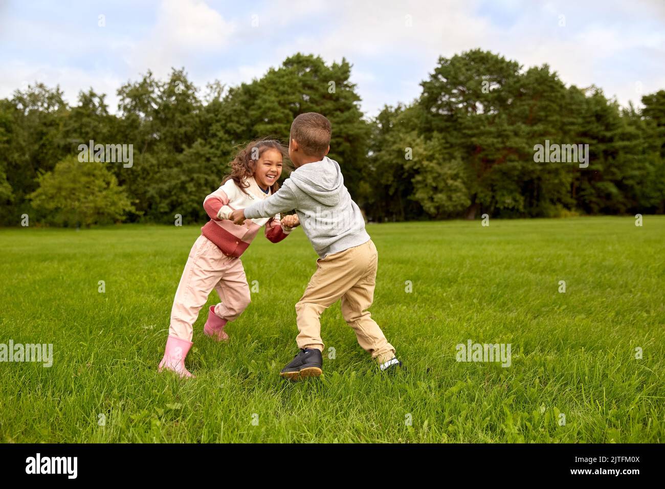 happy little boy and girl having fun at park Stock Photo - Alamy