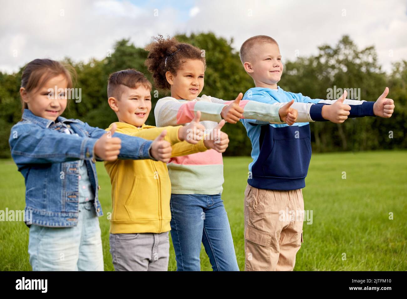 happy children showing thumbs up at park Stock Photo - Alamy