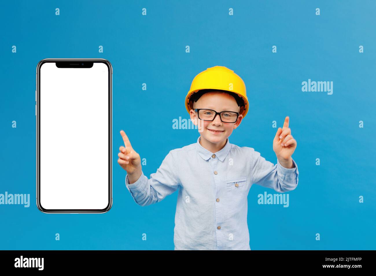 Cute boy construction worker in yellow hard hat standing in indoor