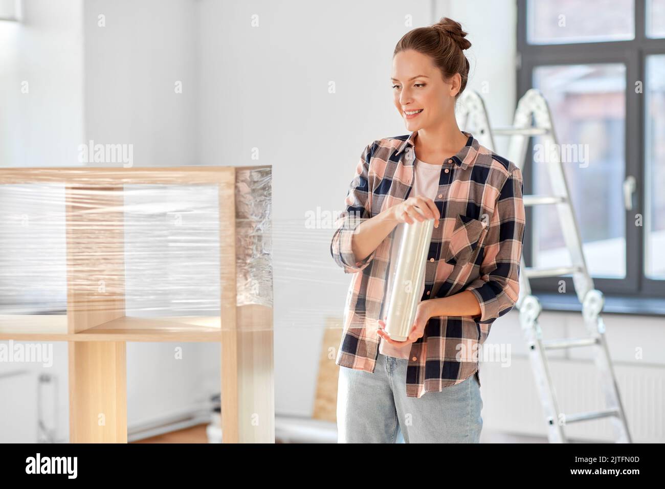 happy woman packing shelf and moving to new home Stock Photo Alamy