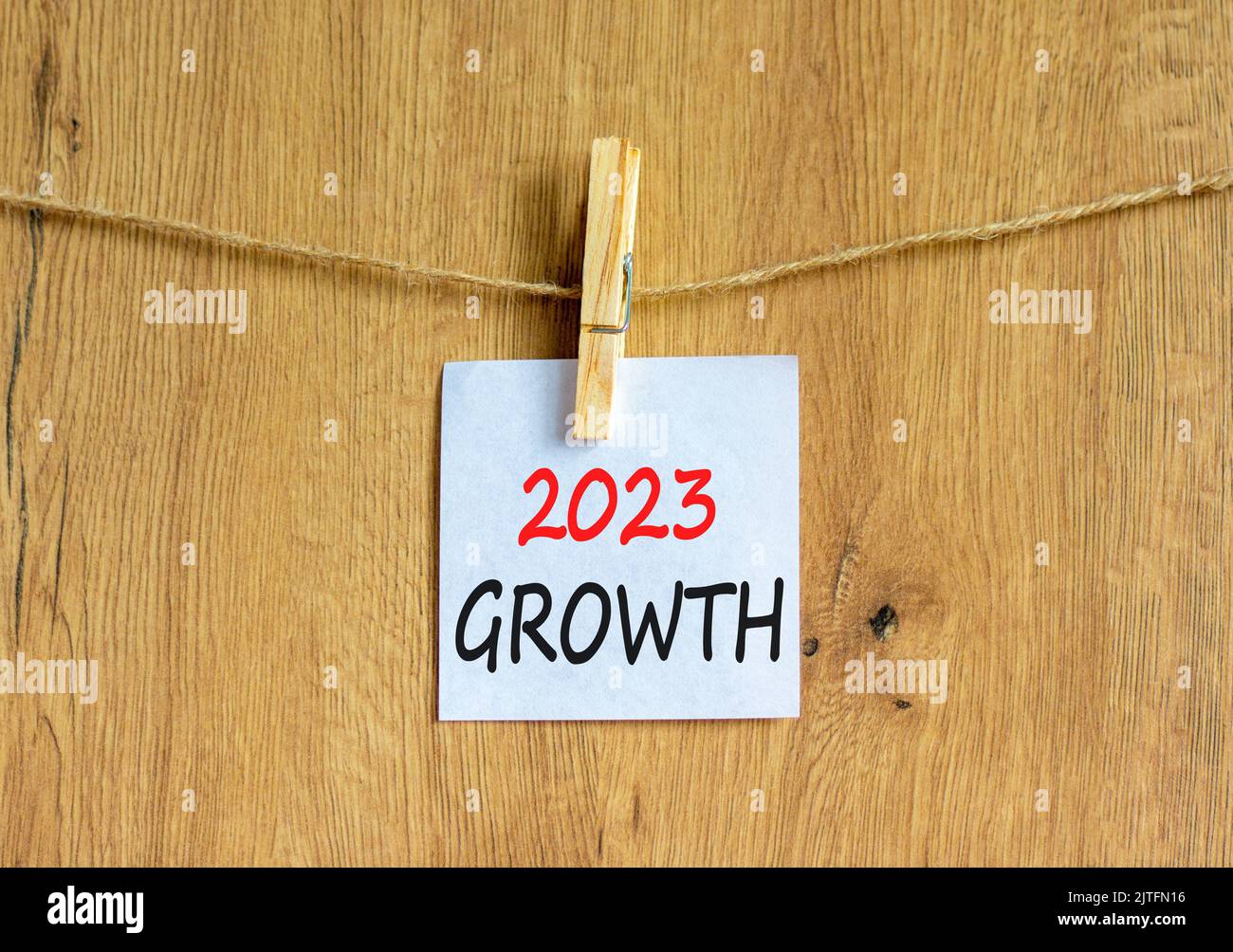 2023 Growth symbol. White paper with words 2023 Growth, clip on wooden clothespin. Beautiful wooden background. Business and 2023 growth concept. Copy Stock Photo