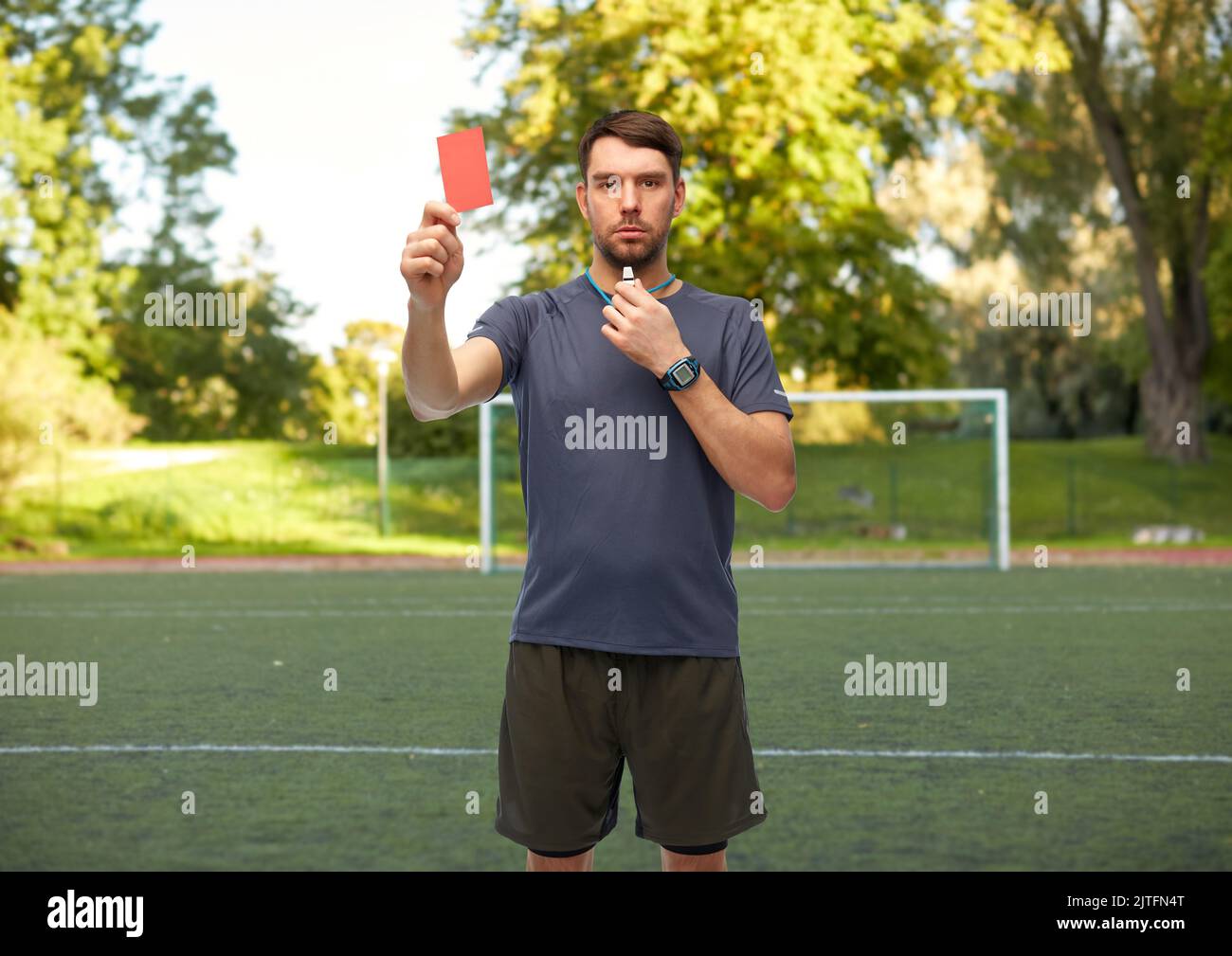 soccer referee with whistle showing red card Stock Photo