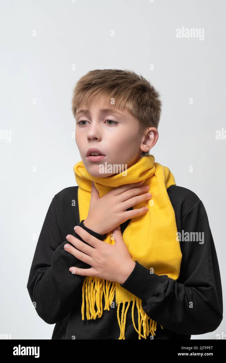 The child has a sore throat, the child is holding his throat with his