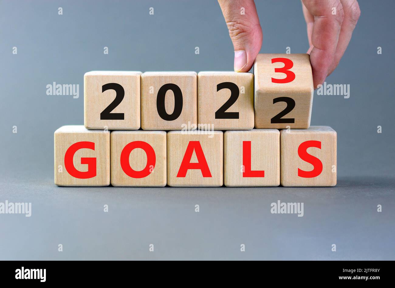 Planning 2023 goals new year symbol. Businessman turns a wooden cube