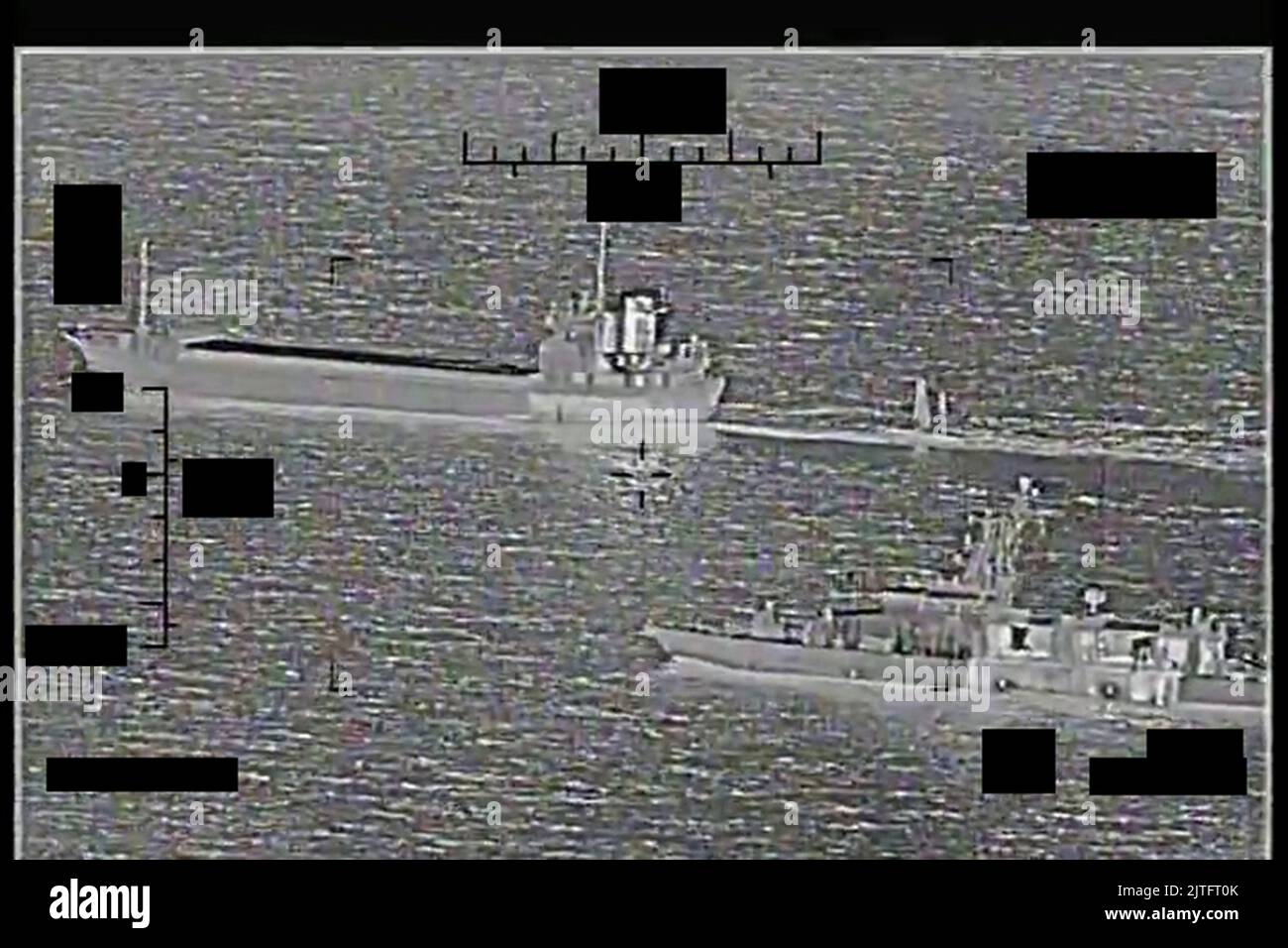 The U.S. Navy prevented a support ship, the Shahid Baziar, left, belonging to Iran's Islamic Revolutionary Guard Corps Navy (IRGCN), from capturing an unmanned surface vessel (USV) operated by the U.S. 5th Fleet in the Arabian Gulf on August 29-30, 2022. The actions taken by U.S. naval forces in response resulted in the IRGCN vessel disconnecting the towing line to the USV and departing the area approximately four hours later. The U.S. Navy resumed operations without further incident. The U.S. Navy patrol coastal ship USS Thunderbolt (PC 12), seen here in a screenshot taken from a video, appro Stock Photo