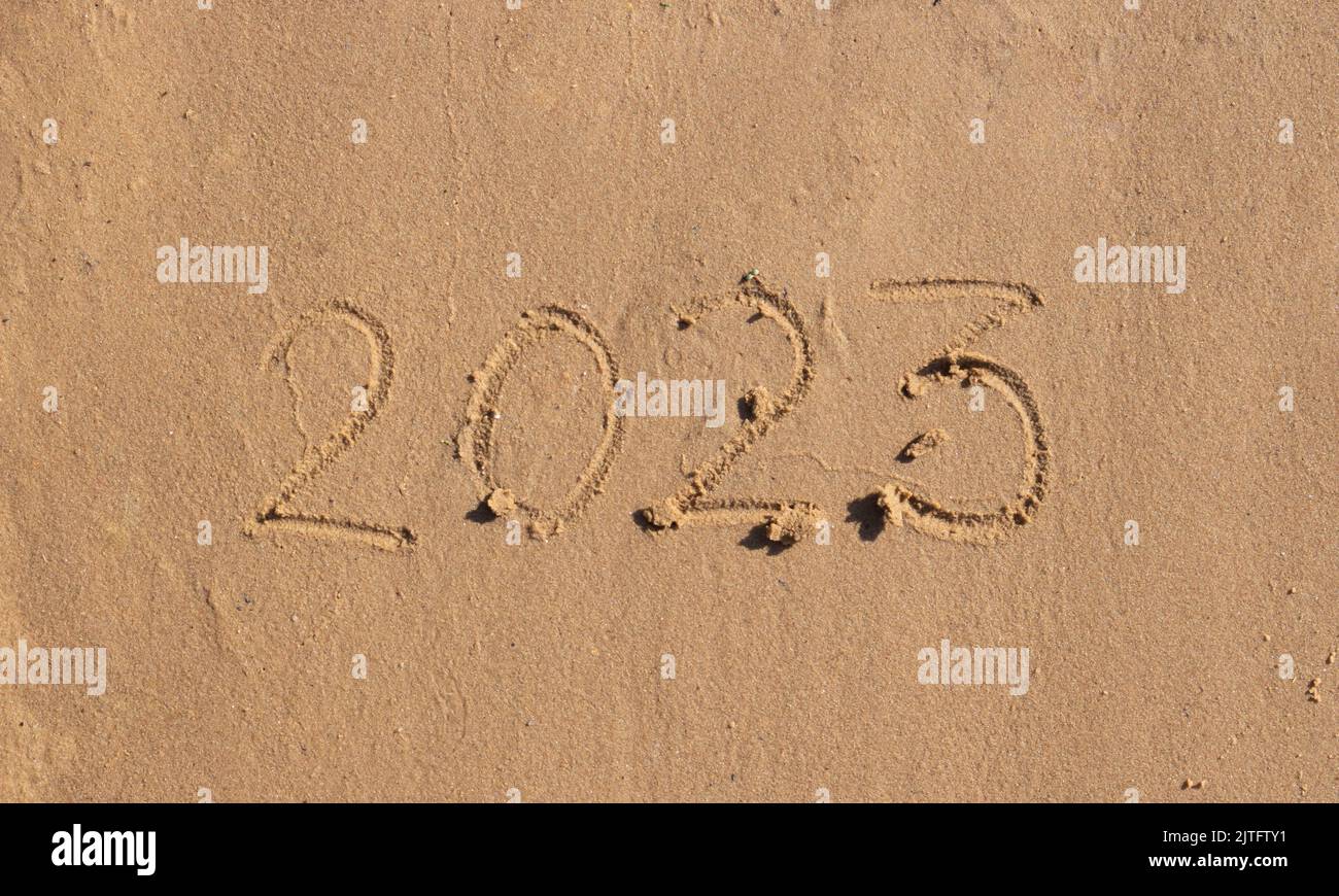 The numbers 2023 are written on the sand on the beach. The concept of the New Year. Happy New Year 2023 background. Travel during the Christmas holida Stock Photo