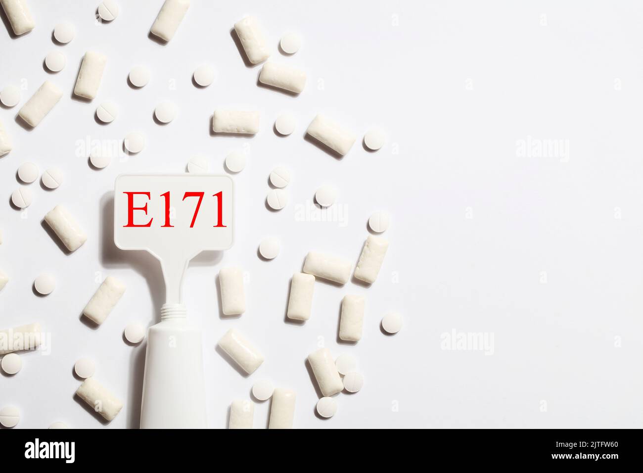 Titanium dioxide, E171, dangerous additive concept. gum, pills, toothpaste or cream and sign with E171 on white background. copy space Stock Photo