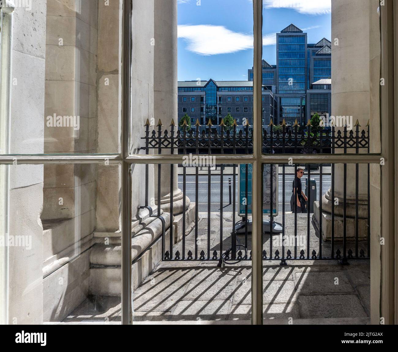The Ulster Bank Headquarters on Georges Quay in Dublin, Ireland viewed through a window of the Customs House  on Custom House Quay. Stock Photo