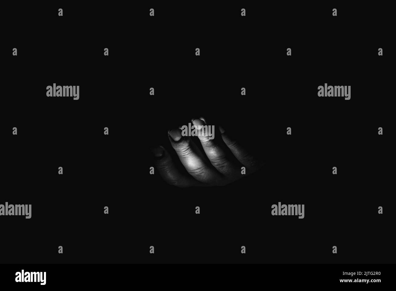 Male hand in the dark, black and white photo, fear and horror, a hand asking for help Stock Photo