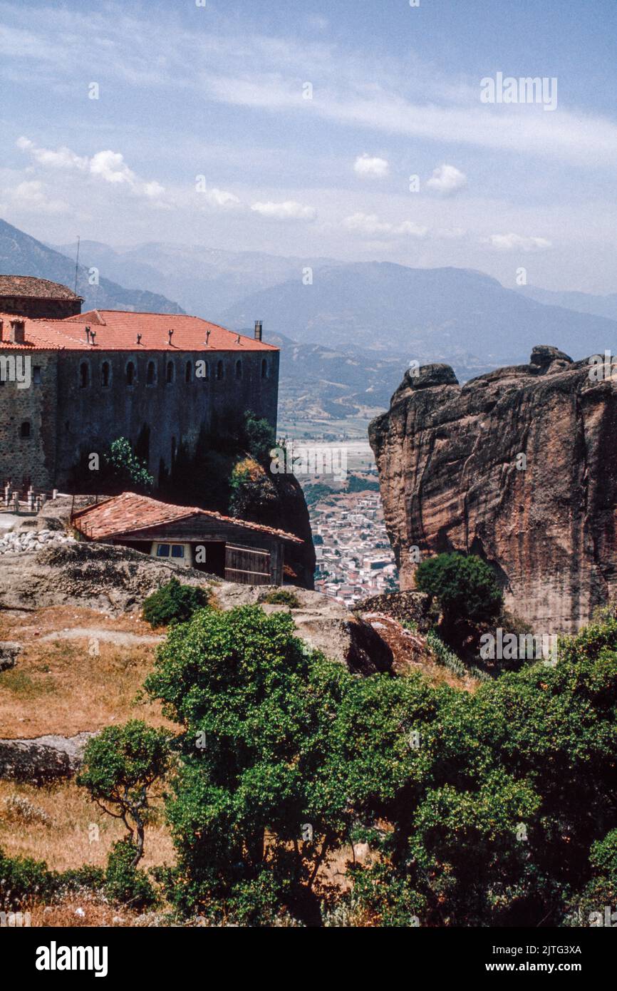 View on Kalambaka town through The Meteora - a rock formation in central Greece hosting one of the largest and most precipitously built complexes of Eastern Orthodox monasteries. March 1980. Archival scan from a slide. Stock Photo