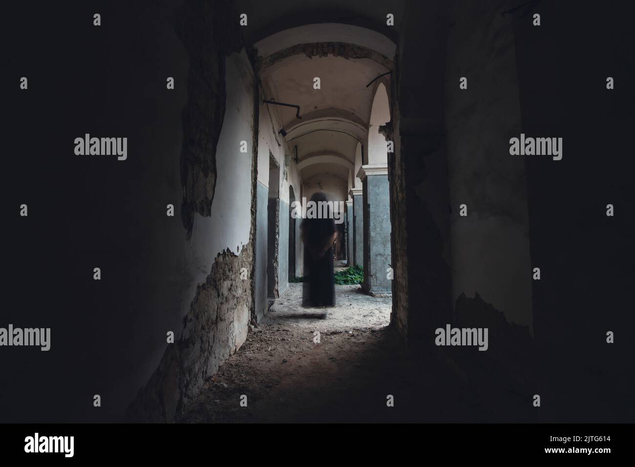 Ghost in abandoned, haunted house. Horror scene of scary spirit of a woman, halloween concept. Stock Photo