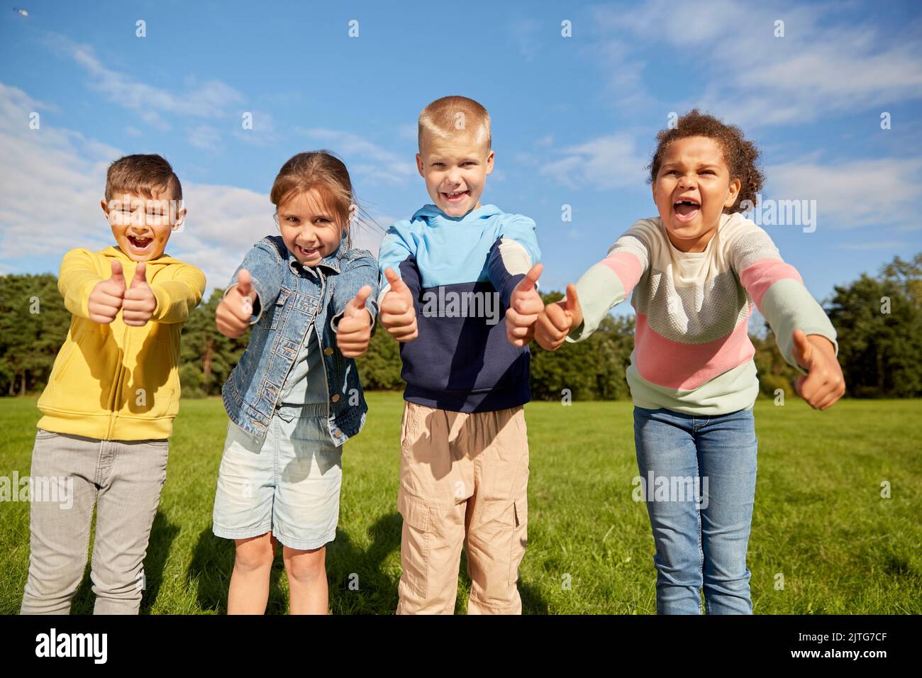 happy children showing thumbs up at park Stock Photo - Alamy
