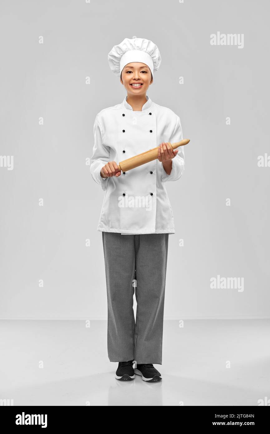 smiling female chef or baker with rolling pin Stock Photo