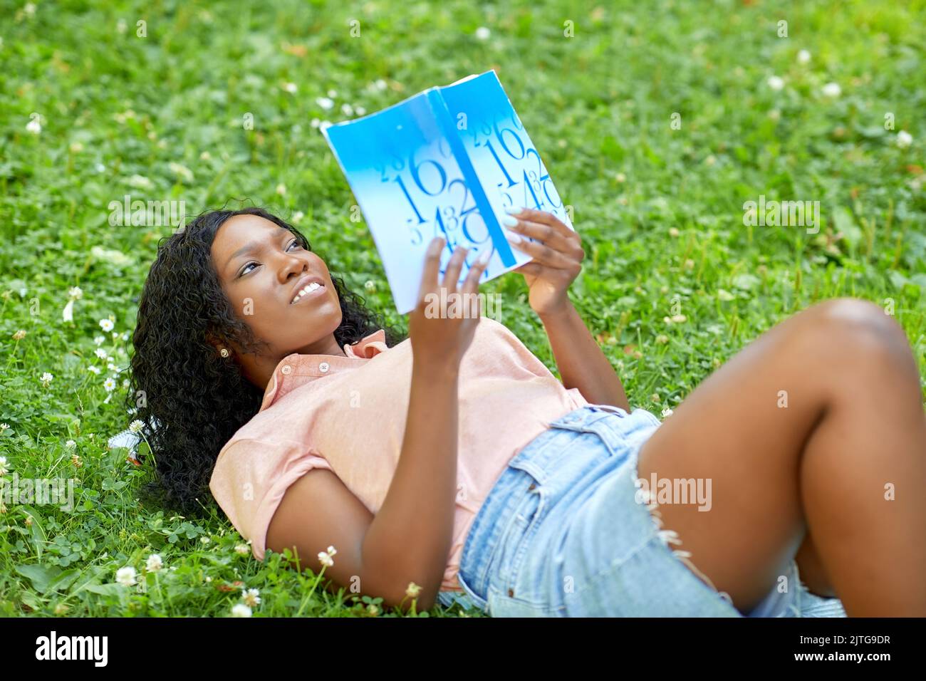 african student girl reading math textbook Stock Photo - Alamy