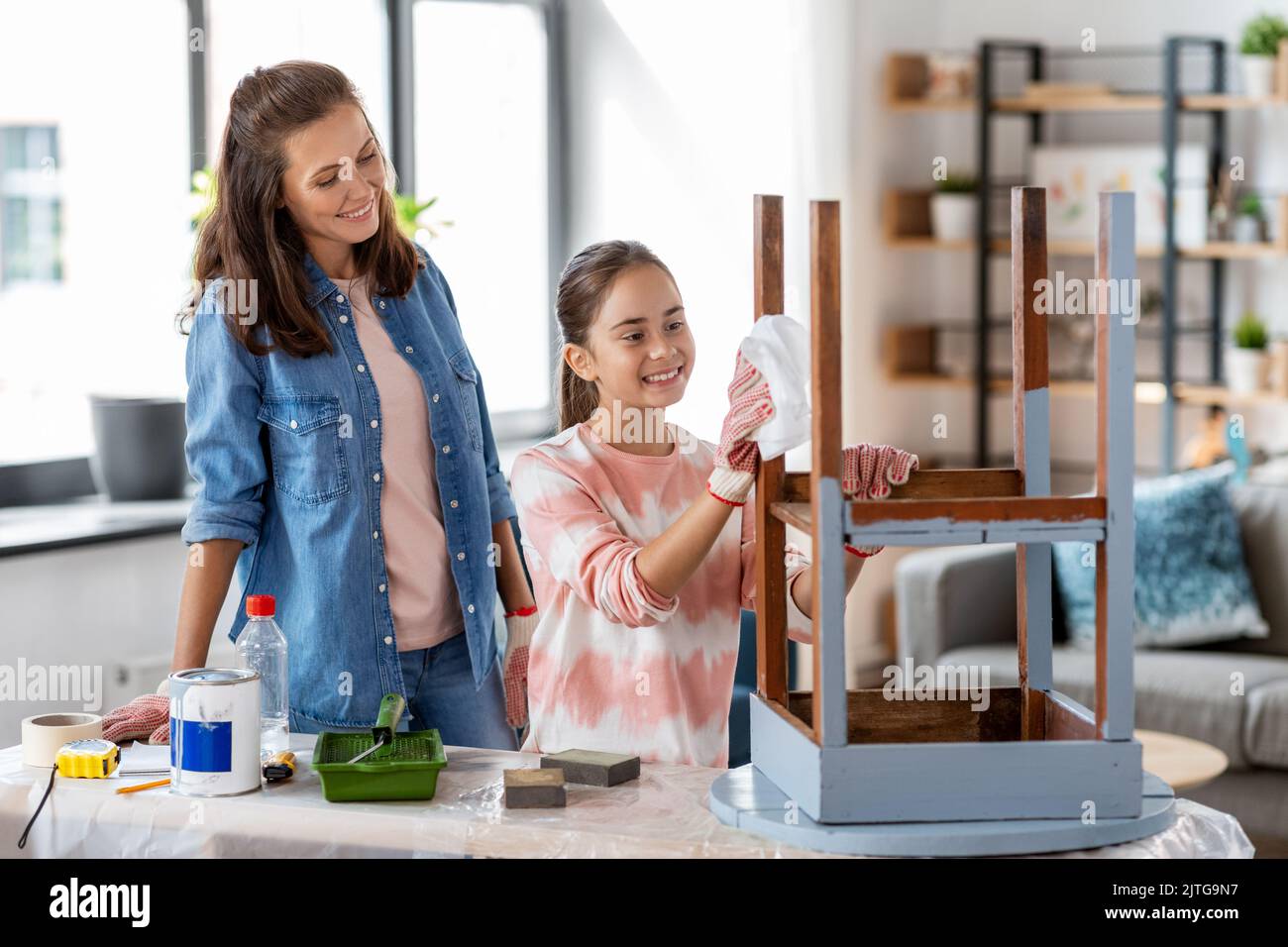 mother and daughter cleaning old table with tissue Stock Photo Alamy