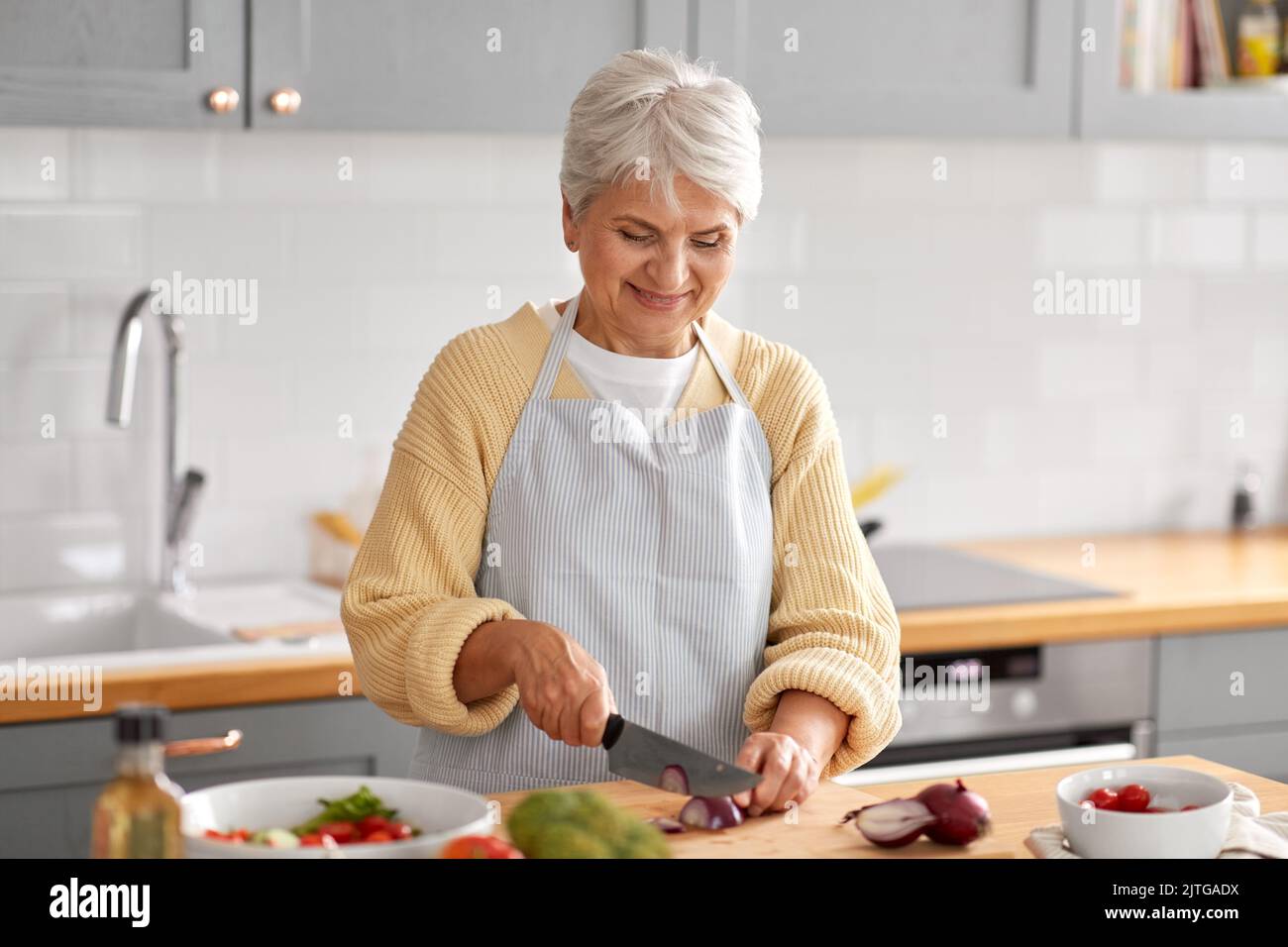 happy woman chopping red onion on kitchen Stock Photo - Alamy